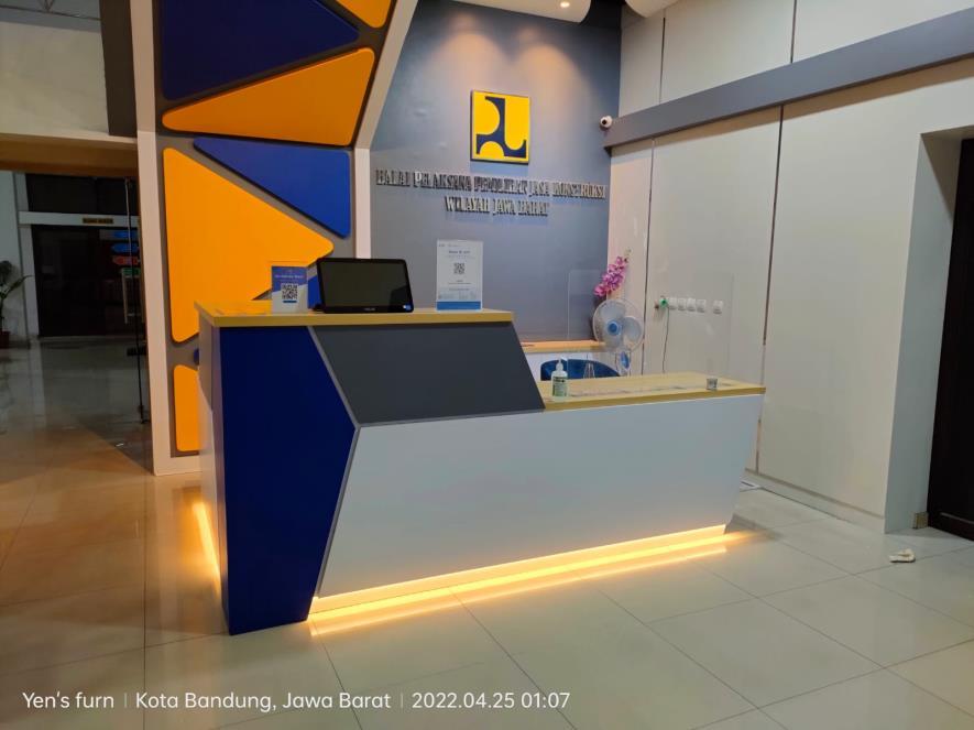 Meja resepsionis dengan panel geometris biru dan kuning